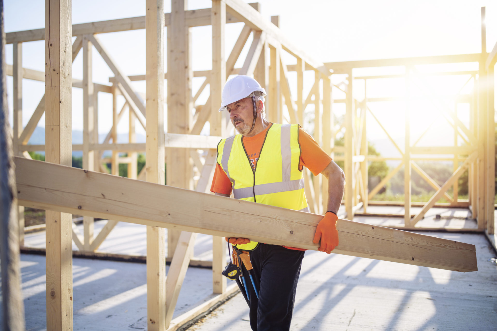 Builder Working On Wooden House